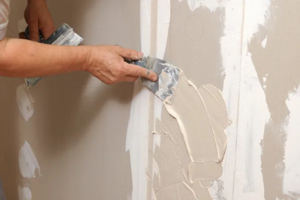 An showing us applying plaster to a wall